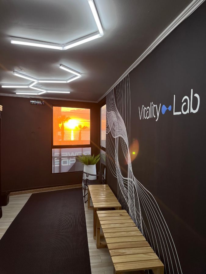 Recepción de Vitality Lab con el mural de líneas y vista al mar