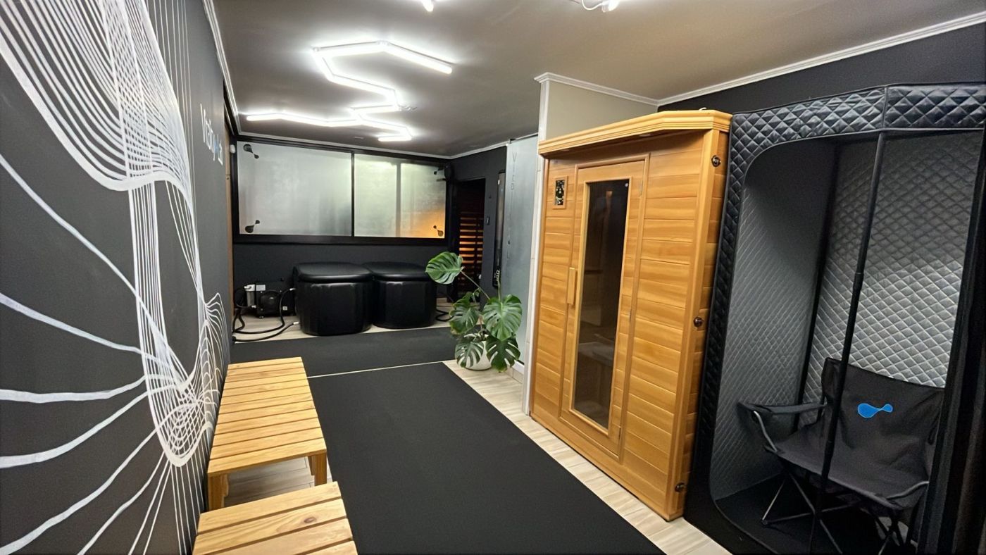 Sala de recuperación con sauna infrarrojo, cabina de vapor, tinas de frío y el mural de Vitality Lab
